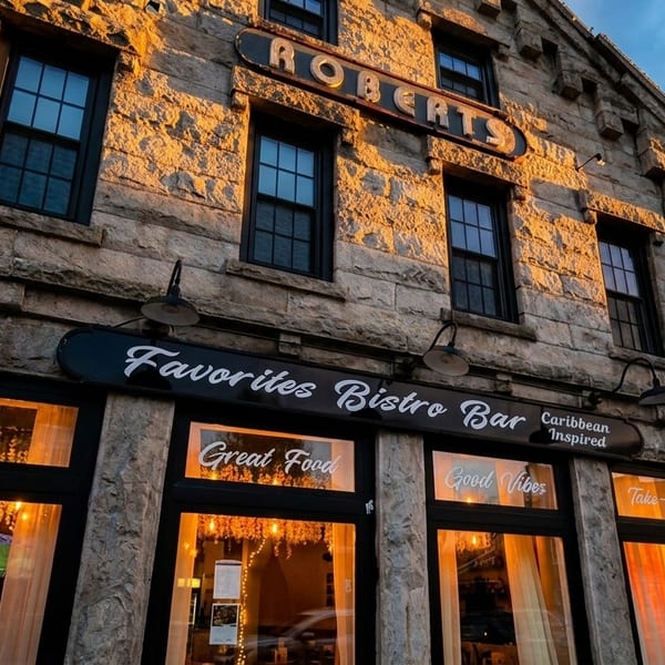 Stone building with "Favorites Bistro Bar" sign, glowing windows, and "Roberts" carved above.